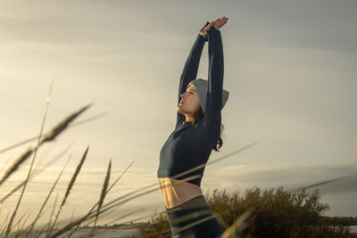 Low angle view of woman standing against sky