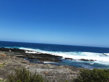 Scenic view of sea against clear blue sky