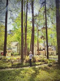 Rear view of man by tree against building