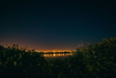 Scenic view of lake against sky at night