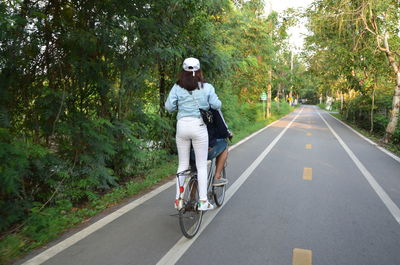 Full length of man riding bicycle on road