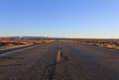 Surface level of country road against clear sky