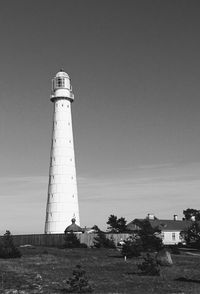 Lighthouse by building against clear sky