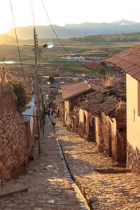 Footpath amidst buildings in town against sky