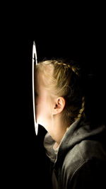 Portrait of boy against black background