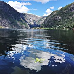 Scenic view of lake and mountains against blue sky