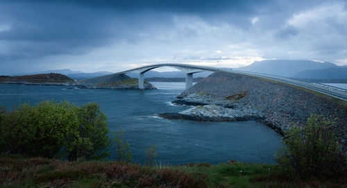 Arch bridge over river against sky