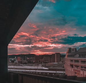 Aerial view of buildings in city against sky at sunset