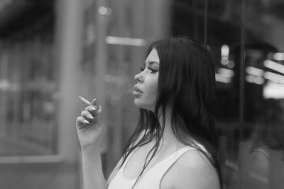 Portrait of young woman smoking cigarette