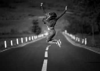 Close-up of woman jumping on road