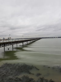 View of bridge over sea against cloudy sky