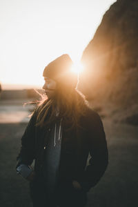 Silhouette woman standing against sea at sunset