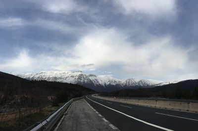 Empty road against cloudy sky