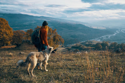 Rear view of man with dog on mountain