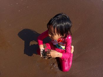 High angle view of girl with toy on sand