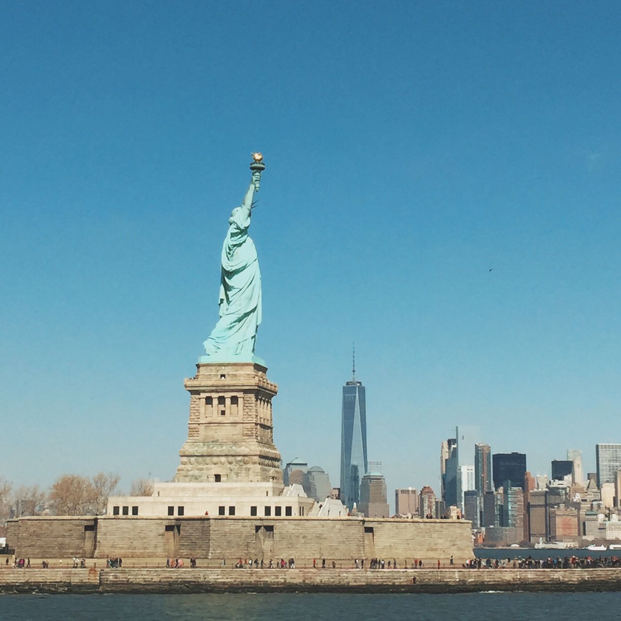 statue, sculpture, clear sky, human representation, art and craft, water, built structure, architecture, famous place, art, waterfront, copy space, building exterior, international landmark, travel destinations, blue, creativity, statue of liberty