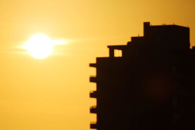 Silhouette buildings against sky during sunset