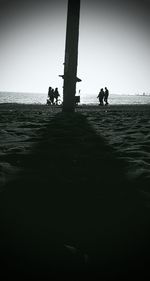 People on beach against clear sky