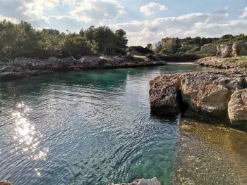 Scenic view of rocks in sea against sky