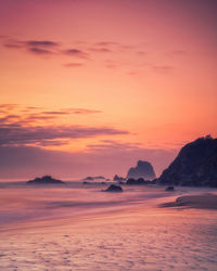 Scenic view of sea against dramatic sky during sunset