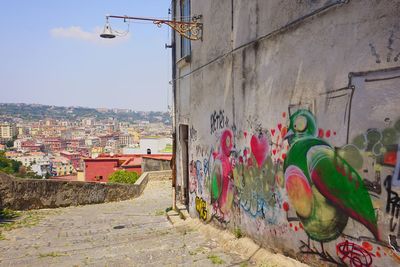 Graffiti on wall in city against sky