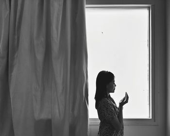 Woman standing in front of window