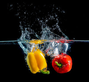 Close-up of yellow water splashing against black background