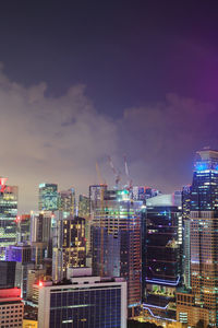 Illuminated buildings in city against sky at night