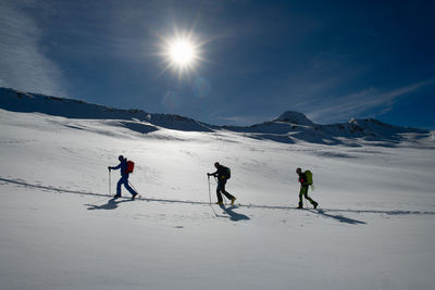 People skiing on snowcapped mountain against sky