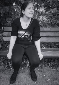 Portrait of teenage girl looking away while sitting on bench