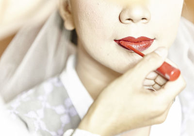 Close-up of bride having lipstick applied