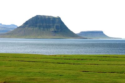 Scenic view of land and mountains against clear sky