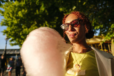 Young woman wearing sunglasses enjoying cotton candy