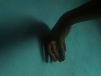 Close-up of hand touching shadow on wall