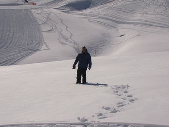 Full length of man standing on snow covered landscape