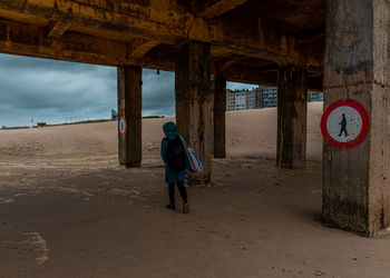 Rear view of woman standing on beach