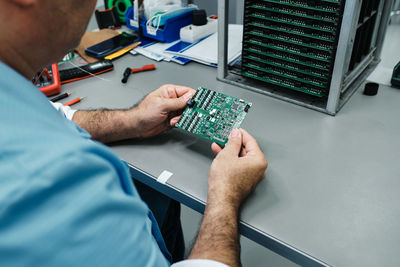 Midsection of man working on table