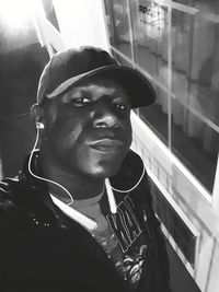 Portrait of young man looking through window