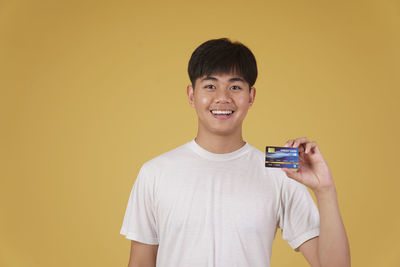 Portrait of a smiling boy against yellow background