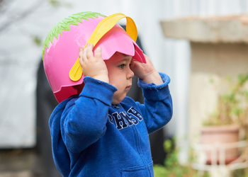 Cute toddler boy pretending to be a football player with an easter basket for a helmet