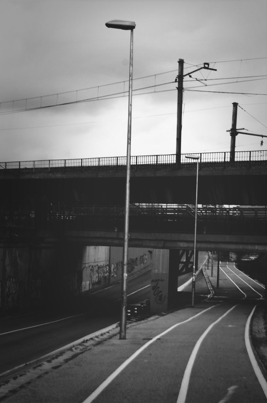 transportation, sky, built structure, architecture, road, power line, railroad track, connection, building exterior, cable, street light, street, electricity pylon, railroad station platform, the way forward, rail transportation, railroad station, road marking, cloud - sky, empty