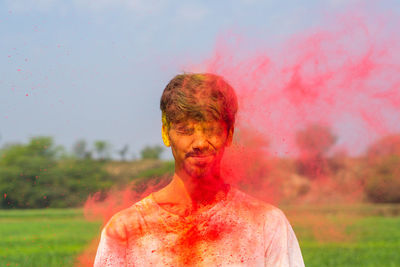 Young man with powder paint outdoors