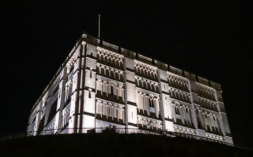 Low angle view of illuminated building against sky at night