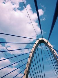 Low angle view of cable-stayed bridge against cloudy sky