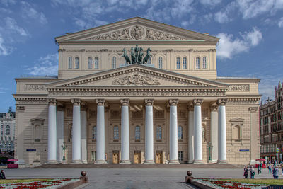 Facade of historical building against cloudy sky