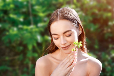 Portrait of a young woman with a leaf in her hand natural background