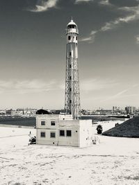 Tower on beach against sky