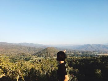 Woman looking at landscape against clear sky