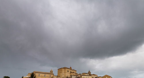 Low angle view of old building against cloudy sky