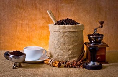 Close-up of coffee with equipment and beans on table